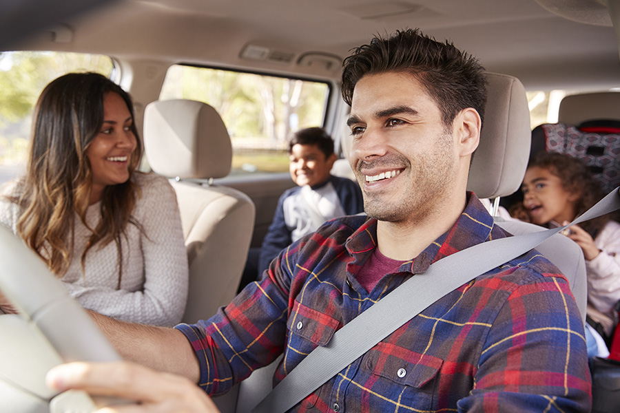 Personal Insurance - Mother Turning Around to Speak to Her Children in the Back Seat of Car During a Family Outing